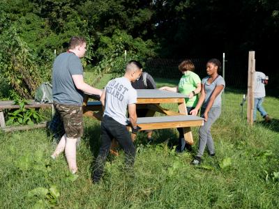 students, staff and coast guard move picnic tables